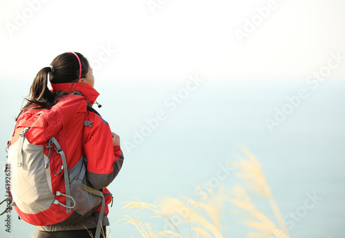   woman hiker  enjoy the view at seaside mountain peak