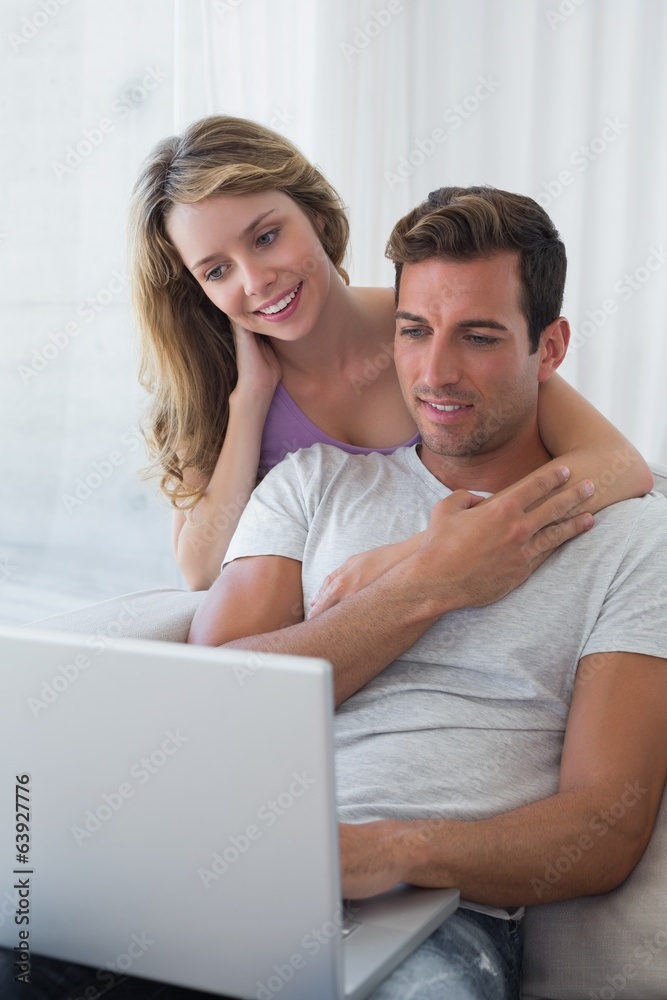 Relaxed couple using laptop on couch Relaxed couple using laptop on couch