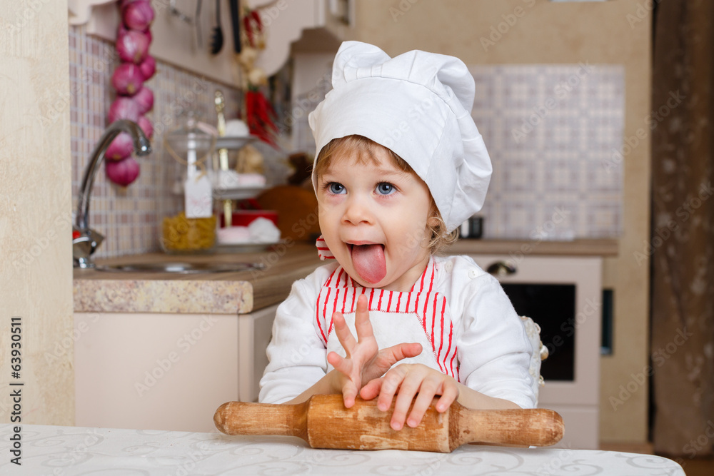 Little girl in apron in the kitchen. Little girl in apron in the kitchen.