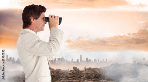 Composite image of businessman using binoculars