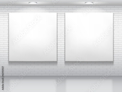 Two blank white pictures on brick wall.