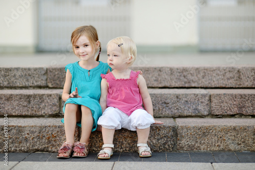 Portrait of two little sisters outdoors