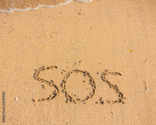 S.O.S written in the sand