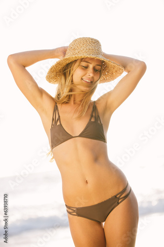 Beautiful girl on the beach at sunset in bikini