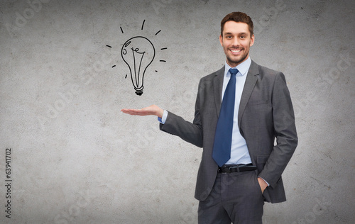 man showing light bulb on the palm of his hand