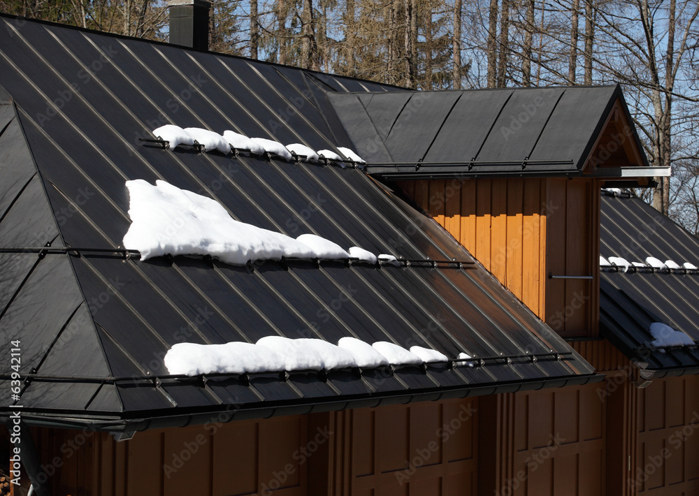 Obraz premium Metal roof of house with snow