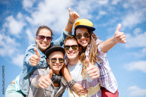 Fotografie smiling teenagers in sunglasses hanging outside