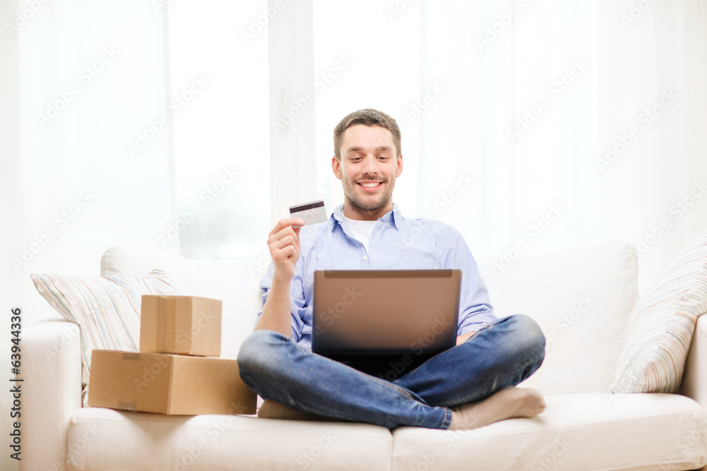 man with laptop, credit card and cardboard boxes