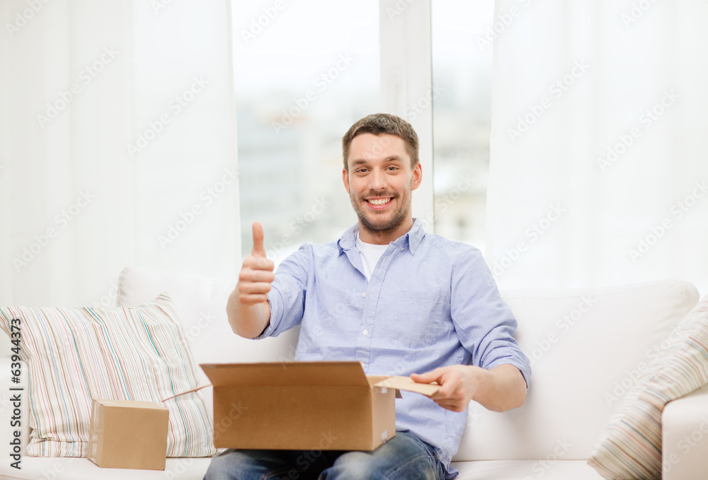 man with cardboard boxes at home showing thumbs up man with cardboard boxes at home showing thumbs up