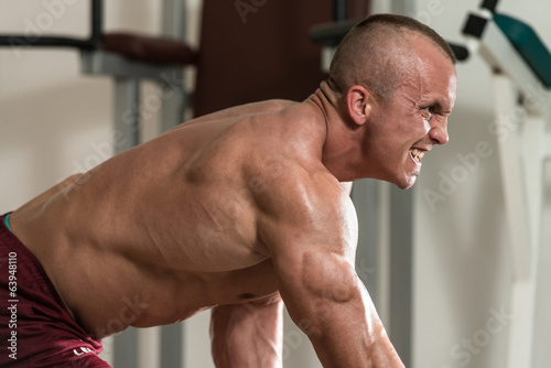 Healthy Man Doing Back Exercises With Dumbbell