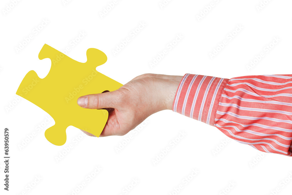 male hand with yellow puzzle piece male hand with yellow puzzle piece