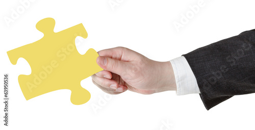 male hand with yellow puzzle piece