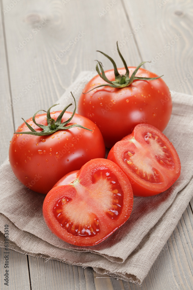 fresh ripe tomatoes with halfs on wood table fresh ripe tomatoes with halfs on wood table