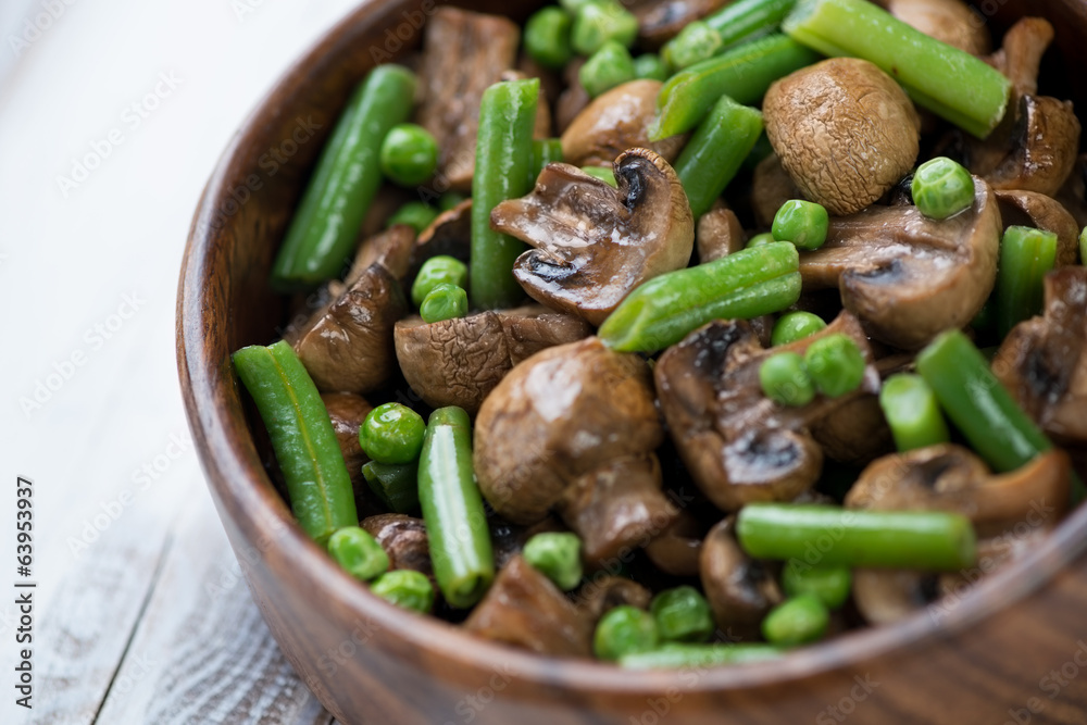 Close-up of fried champignons with peas and beans, studio shot Close-up of fried champignons with peas and beans, studio shot