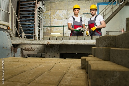 Worker and foreman performing quality check on a factory