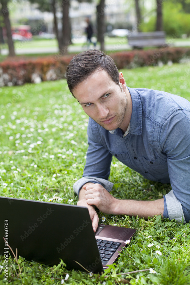 man using laptop at park man using laptop at park