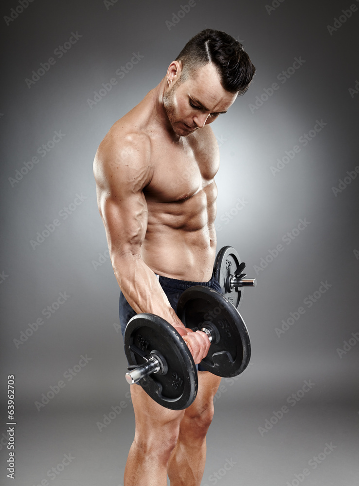 Athletic man working out with dumbbells Athletic man working out with dumbbells