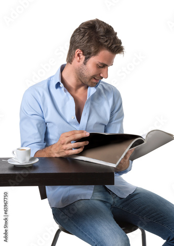 Uomo casual al tavolino con rivista photo