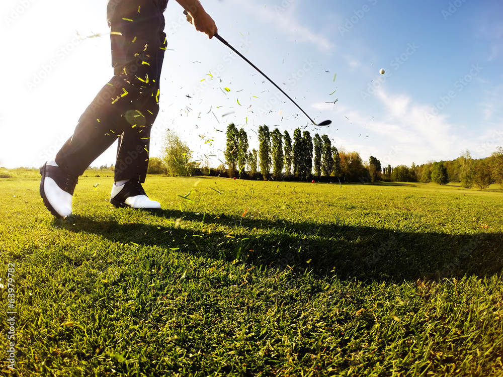 Golfer performs a golf shot from the fairway. - obrazy, fototapety, plakaty 