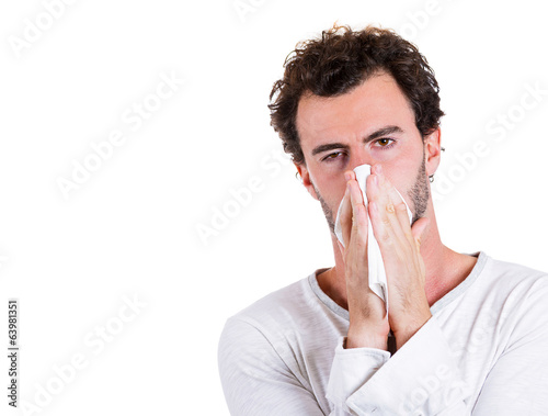 Sick man, blowing his nose, has cold, allergy
