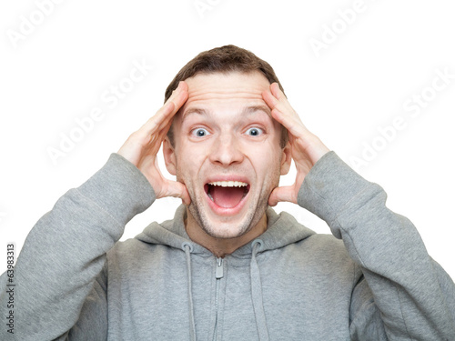 Happy sporty young Caucasian man holds his head and laughs. Phot © evannovostro