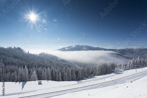 Winter mountain landscape with blue sky and white clouds