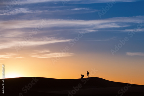 Silhouette of photographers in desert Sahara on sunset, Morocco