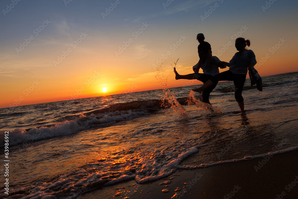 silhouette of happy family on the beach at sunset