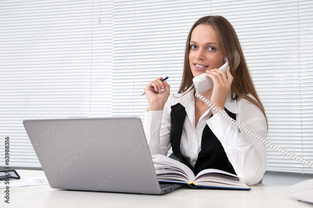 businesswoman on phone looks into camera in her office businesswoman on phone looks into camera in her office