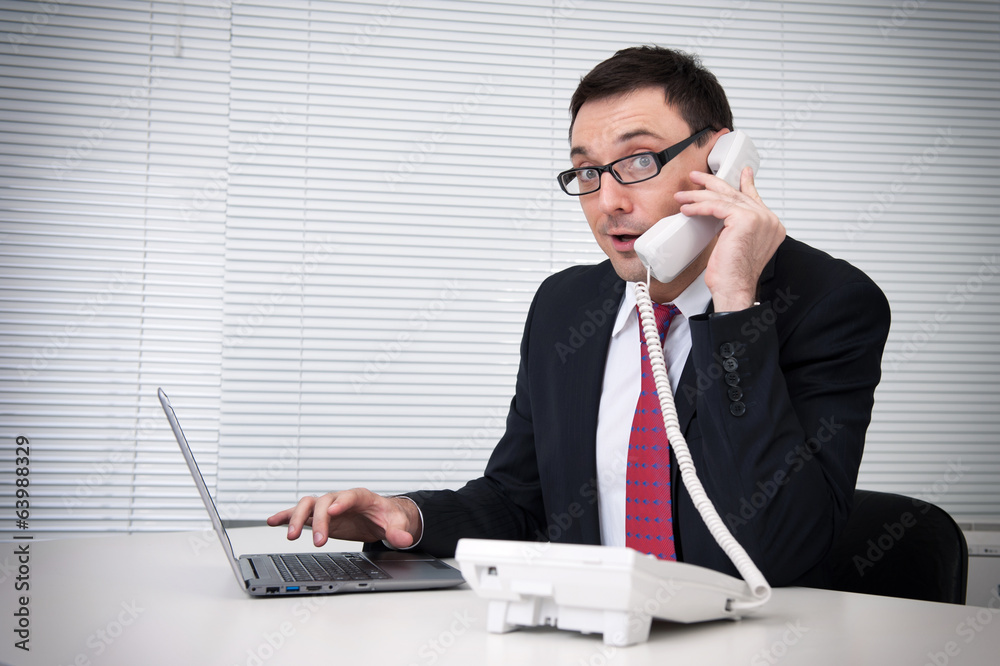 Portrait of businessman talking on mobile phone in office Portrait of businessman talking on mobile phone in office