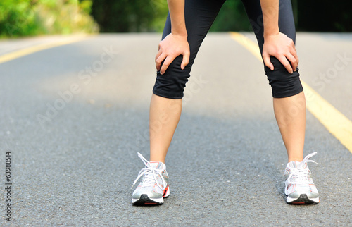 tired female runner taking a rest after running hard outdoor