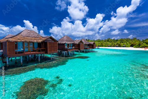 Fototapeta Naklejka Na Ścianę i Meble -  Over water bungalows with steps into green coral lagoon