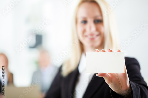 Beautiful young businesswoman holding Blank business card