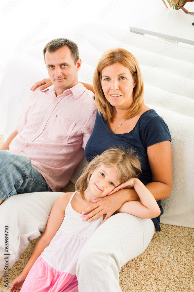 Beautiful happy family sitting on the carpet Beautiful happy family sitting on the carpet