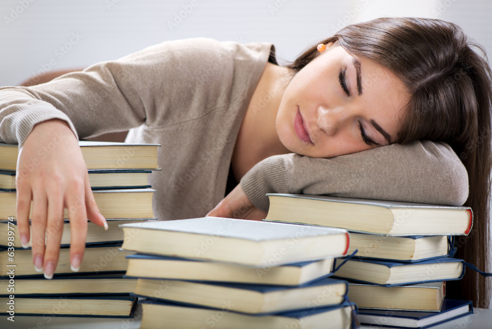 Tired student fell a sleep between many books Tired student fell a sleep between many books