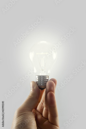holding light bulb isolated on white