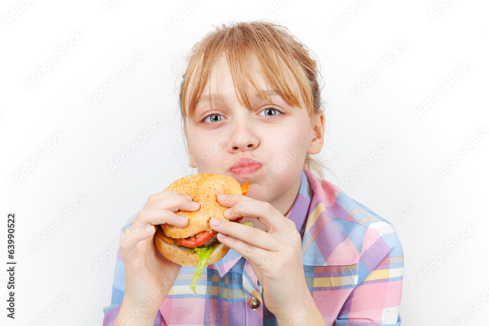 Little blond girl eats burger on white background Little blond girl eats burger on white background