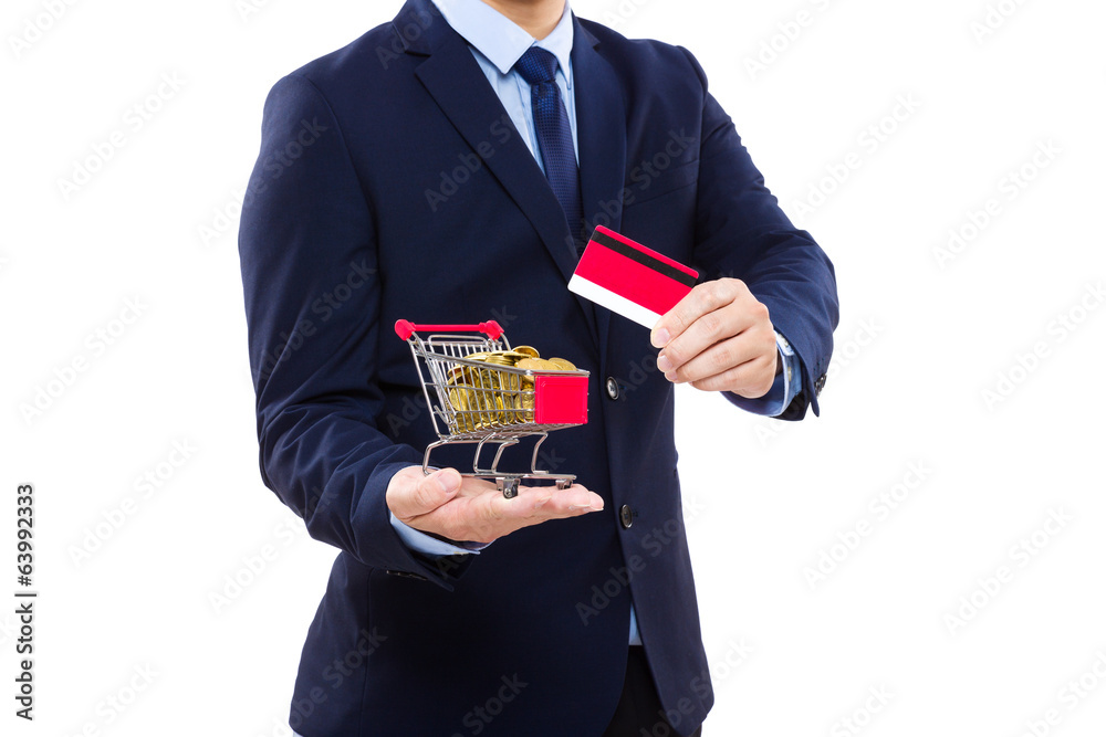 Businessman holding shopping cart with golden coin and credit ca Businessman holding shopping cart with golden coin and credit ca