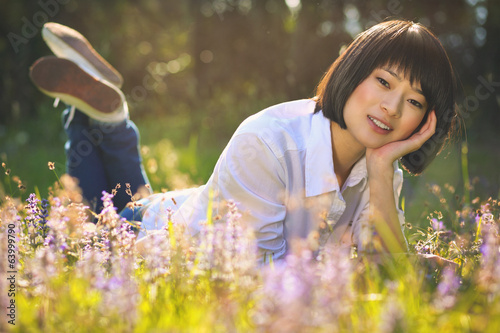 Beautiful asian girl relaxing among flowers