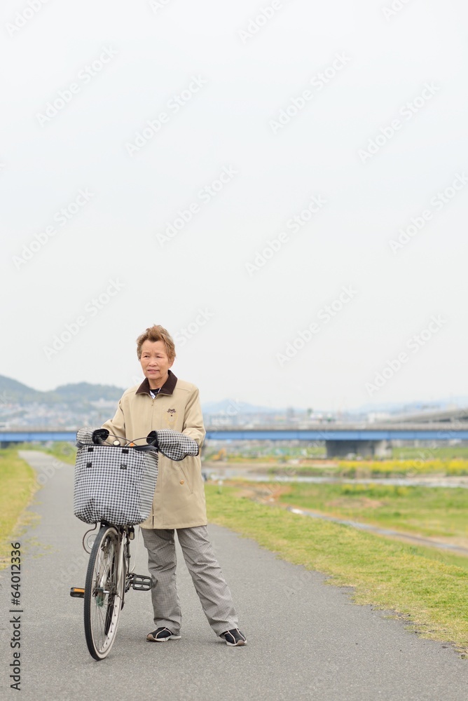 自転車に乗っている高齢者のアジア人女性