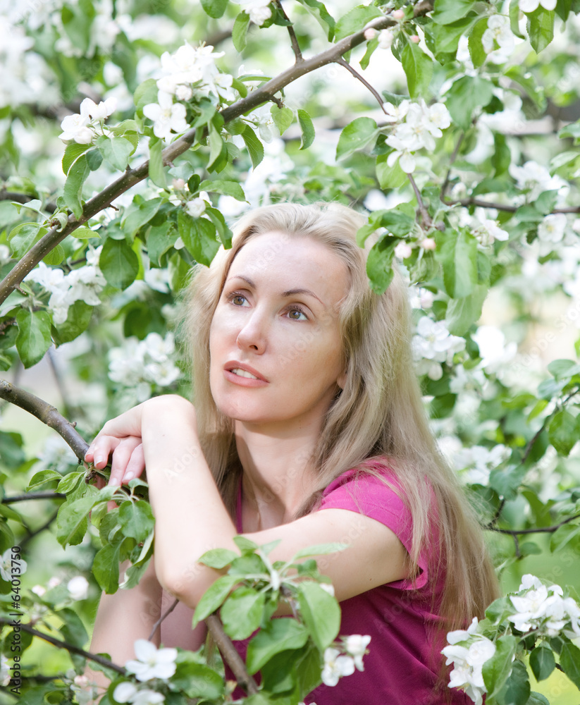 young attractive woman standing near blossoming apple tree... young attractive woman standing near blossoming apple tree...