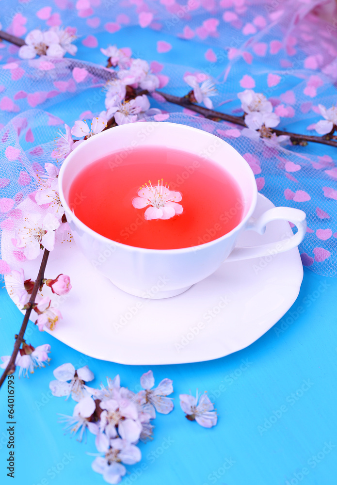 Fragrant tea with flowering branches on wooden table close-up