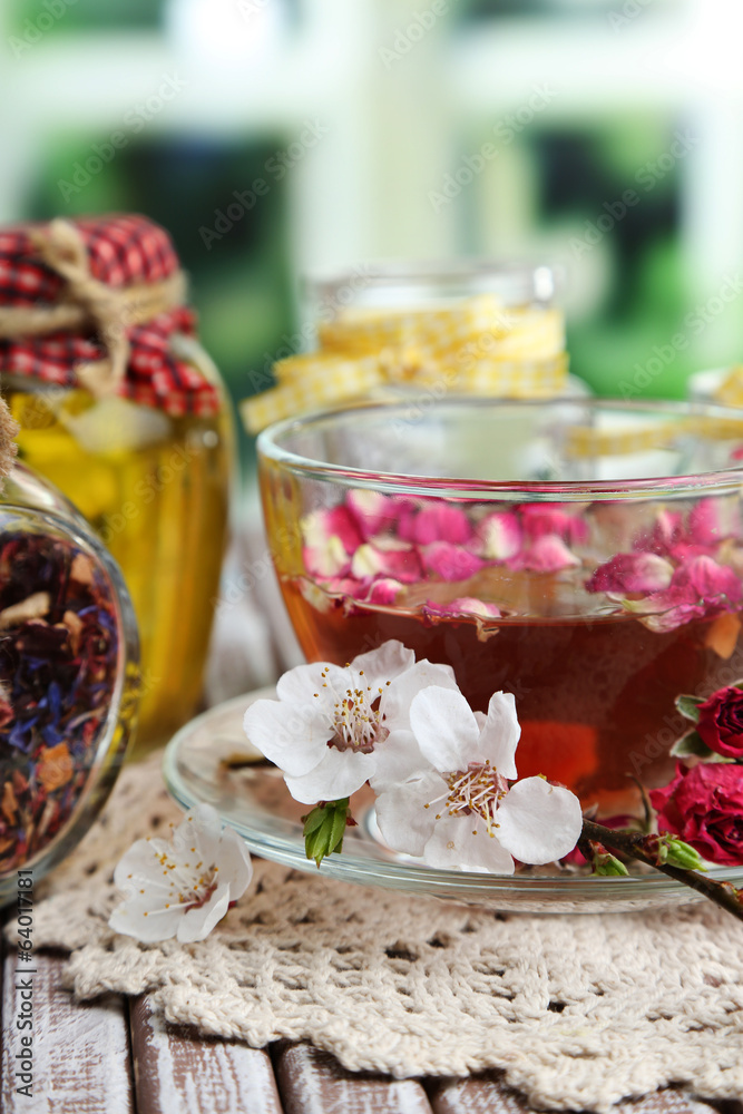 Assortment of herbs,tea and honey in glass jars and cup of hot