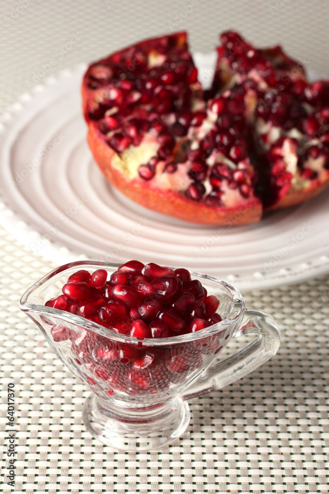 Ripe pomegranate on plate, on light background Ripe pomegranate on plate, on light background