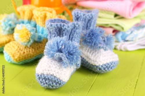 Composition with crocheted booties for baby,clothes, bottles