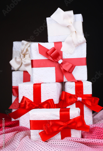 Beautiful gifts with red ribbons on dark background
