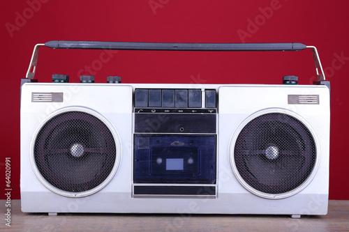 Retro cassette stereo recorder on table on red background
