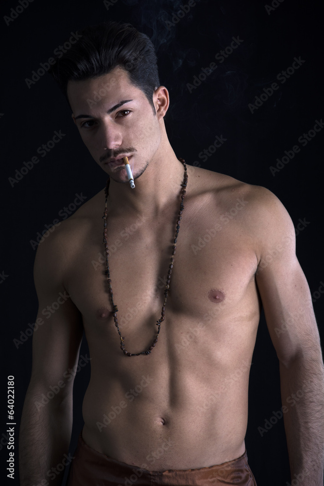 Athletic shirtless young man with mustache smoking Athletic shirtless young man with mustache smoking