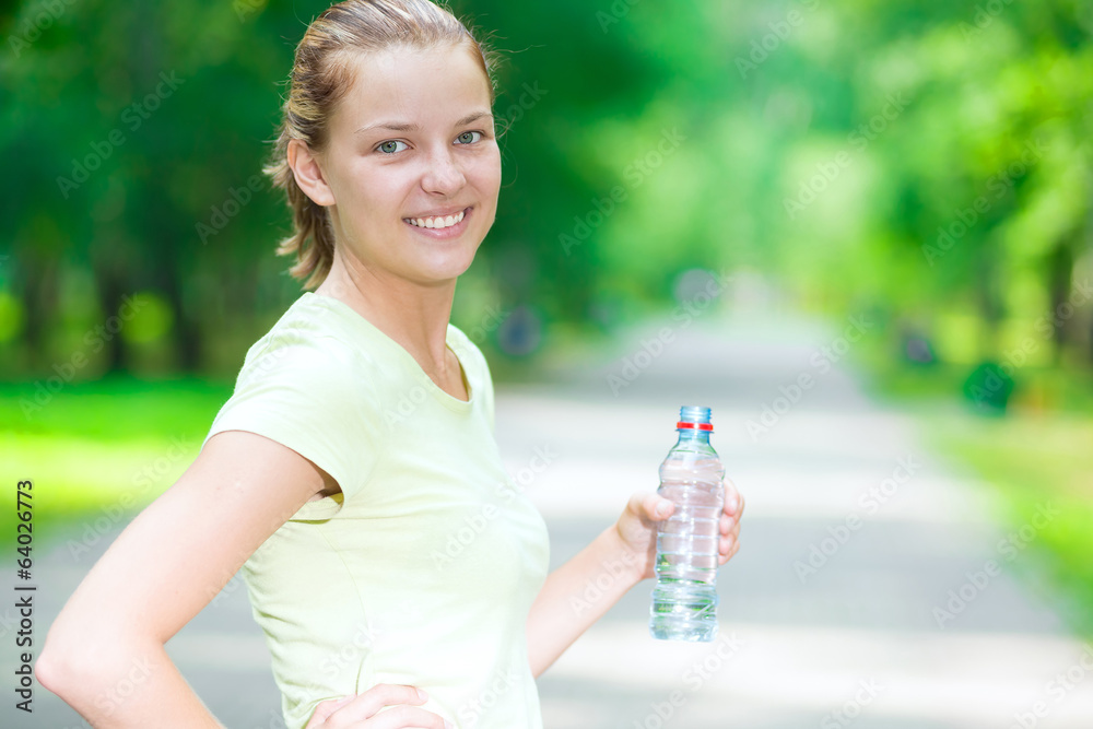 Woman drinking cold mineral water from a bottle after fitness ex Woman drinking cold mineral water from a bottle after fitness ex