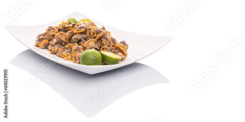 Fresh boiled cockle meat with calamansi fruit in a white plate